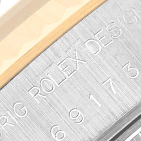 Close-up of the serial number and "ROLEX DESIGN" engraving on the case of a Rolex Datejust 69173 Women's Steel and Gold (two tone) Black Dial 69173 Women's Steel and Gold (two tone) Black Dial watch.