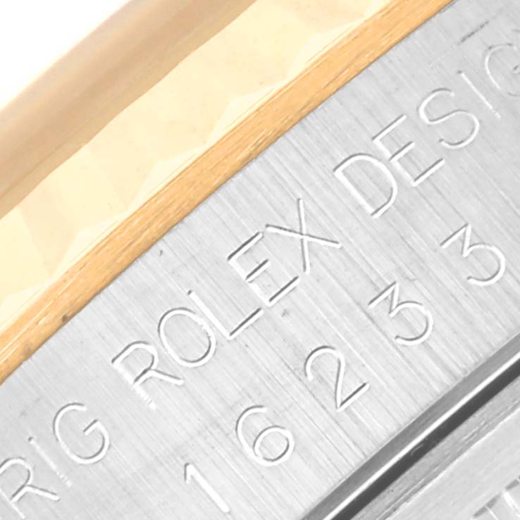 This is a close-up image of the side of a Rolex Datejust 16233 Men's Steel and Gold (two tone) Champagne Dial 16233 Men's Steel and Gold (two tone) Champagne Dial watch, showing the engraved model name and serial number.