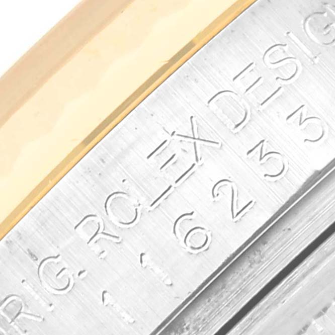 This close-up image shows the engraved edge of the bezel and case of a Rolex Datejust 116233 Men's Steel and Gold (two tone) White Dial 116233 Men's Steel and Gold (two tone) White Dial watch.