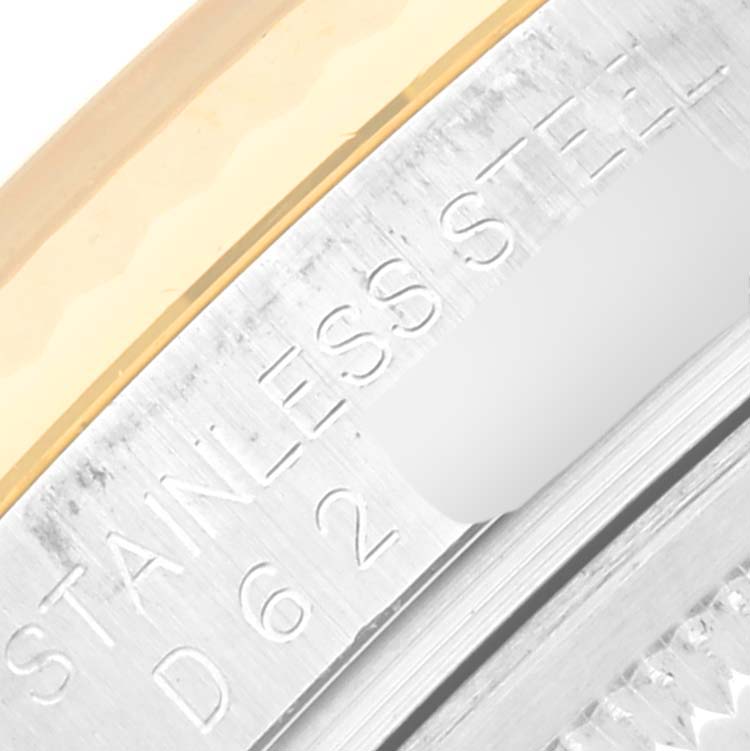 This close-up image of the Rolex Datejust 116233 Men's Steel and Gold (two tone) White Dial 116233 Men's Steel and Gold (two tone) White Dial watch shows a section of its stainless steel case with engraved markings.