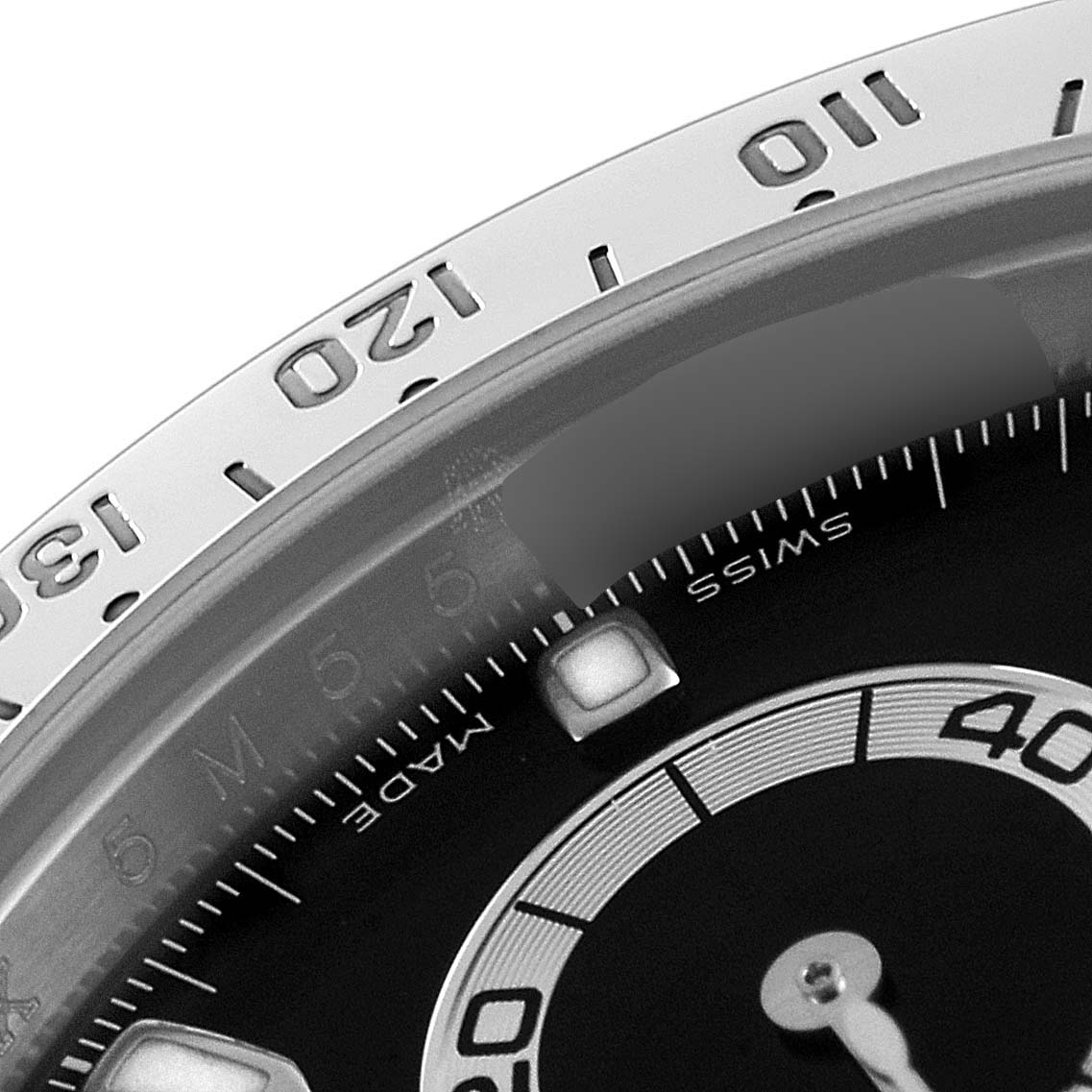 The image shows a close-up view of the bezel and dial of a Rolex Daytona 116520 Men's Stainless Steel Black Dial 116520 Men's Stainless Steel Black Dial watch, highlighting the minute markers and numerals.
