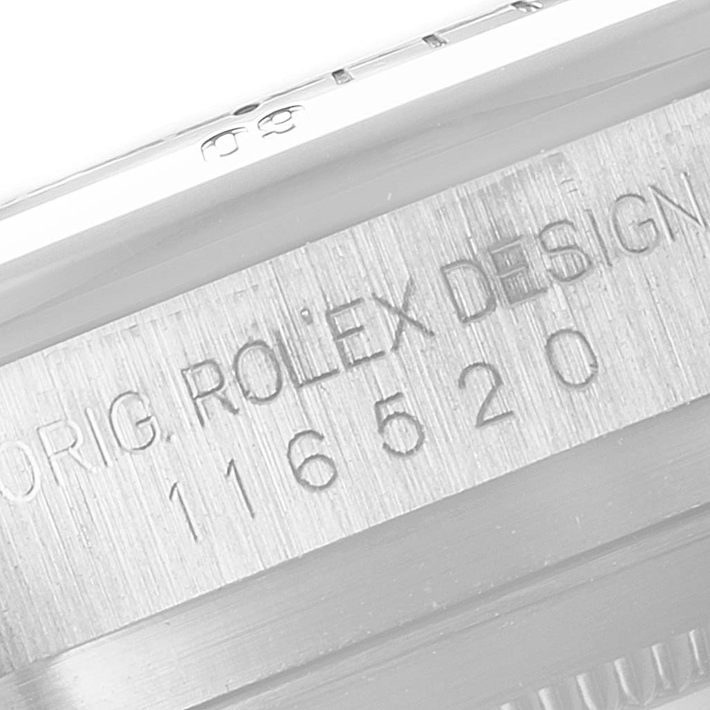 The image shows a close-up of the Rolex Daytona 116520 Men's Stainless Steel Black Dial 116520 Men's Stainless Steel Black Dial model's engraved serial number and "ROLEX DESIGN" text.
