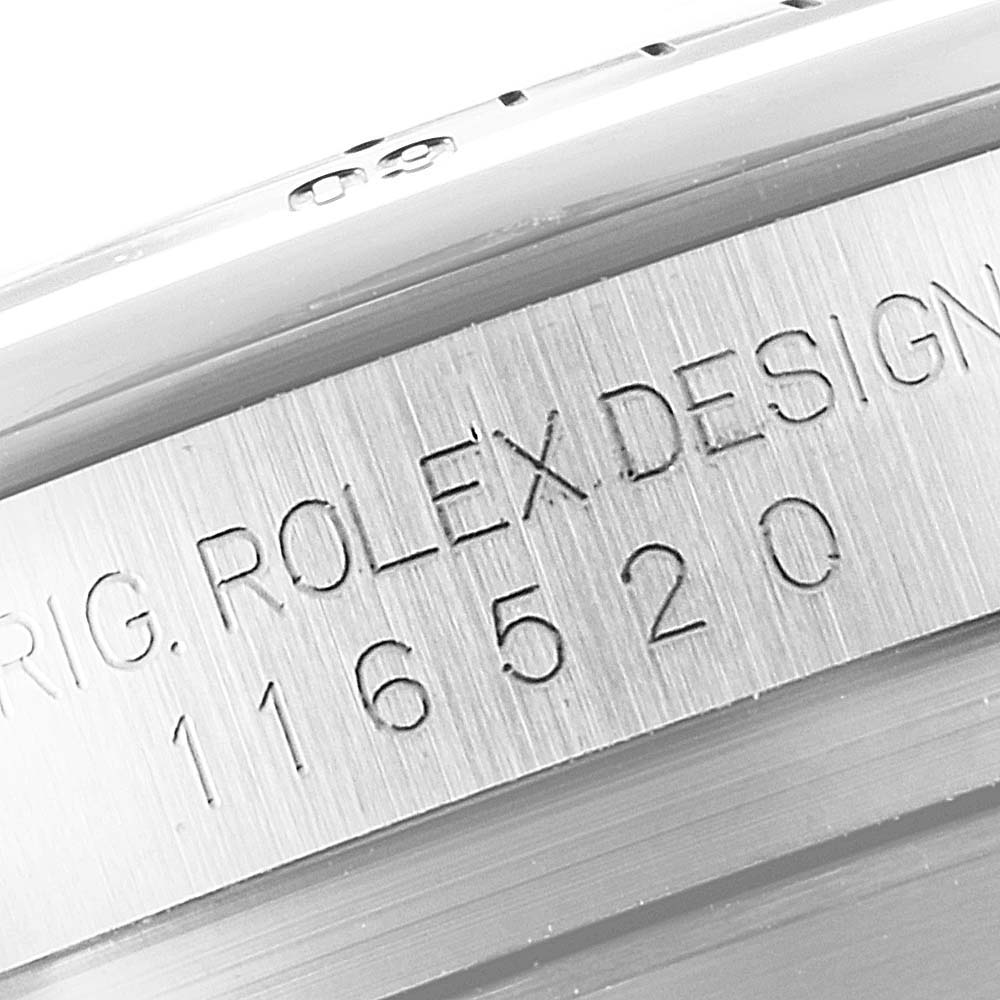 The image shows a close-up of the model number "116520" and the "ORIG. ROLEX DESIGN" engraving on the side of a Rolex Daytona 116520 Men
s Stainless Steel Black Dial 116520 Men
s Stainless Steel Black Dial watch case.