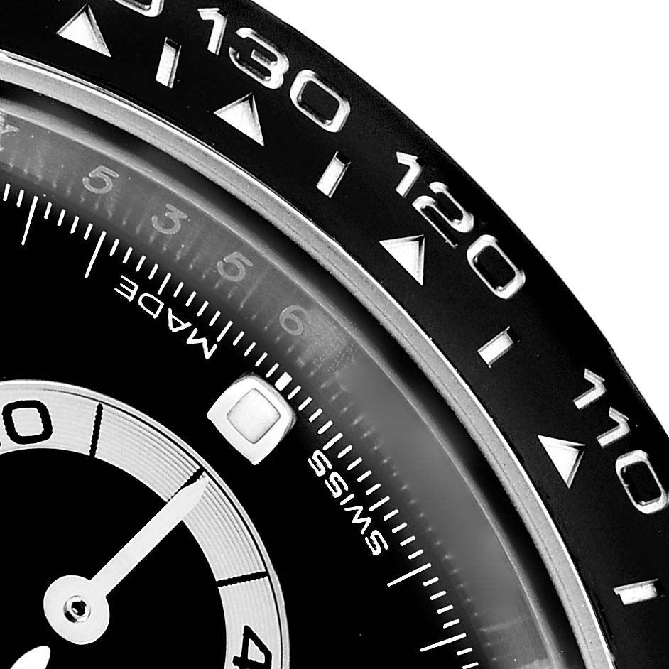 The image shows a close-up of the bezel and part of the dial of a Rolex Daytona 116500 Men
s Stainless Steel Black Dial, highlighting the tachymetric scale.