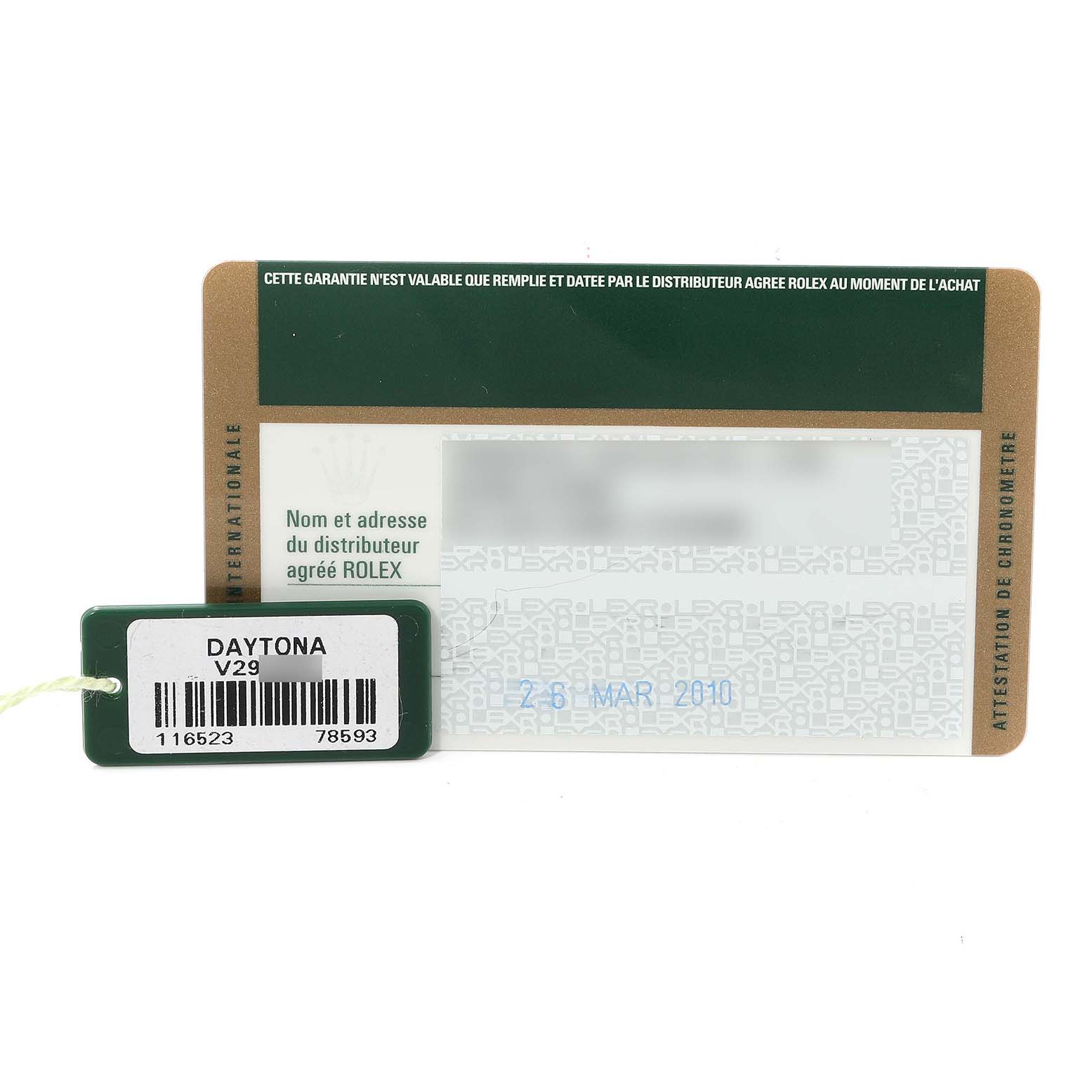 The image shows a Rolex Daytona 116523 Men
s Steel and Gold (two tone) Black Dial 116523 Men
s Steel and Gold (two tone) Black Dial warranty card and a tag with the model
s barcode and reference number.