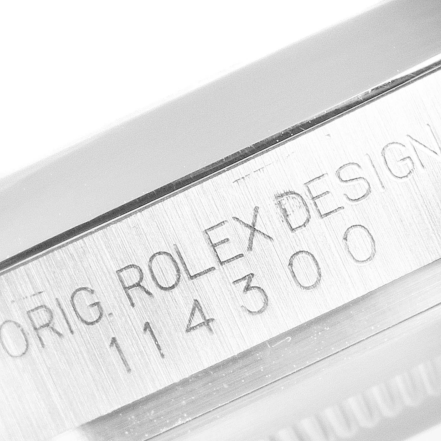 The image shows a close-up of the case side of a Rolex Oyster Perpetual 114300 Men's Stainless Steel Burgundy Dial 114300 Men's Stainless Steel Burgundy Dial watch, highlighting the engraved serial number.