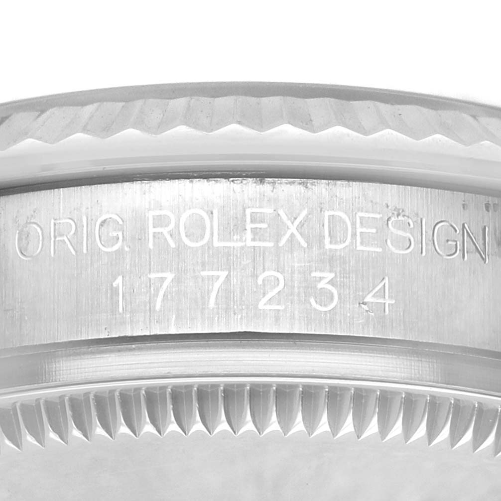 The image shows the side of a Rolex Oyster Perpetual 177234 Women's Stainless Steel Black Dial watch case, highlighting engraved details and the serrated bezel edge.