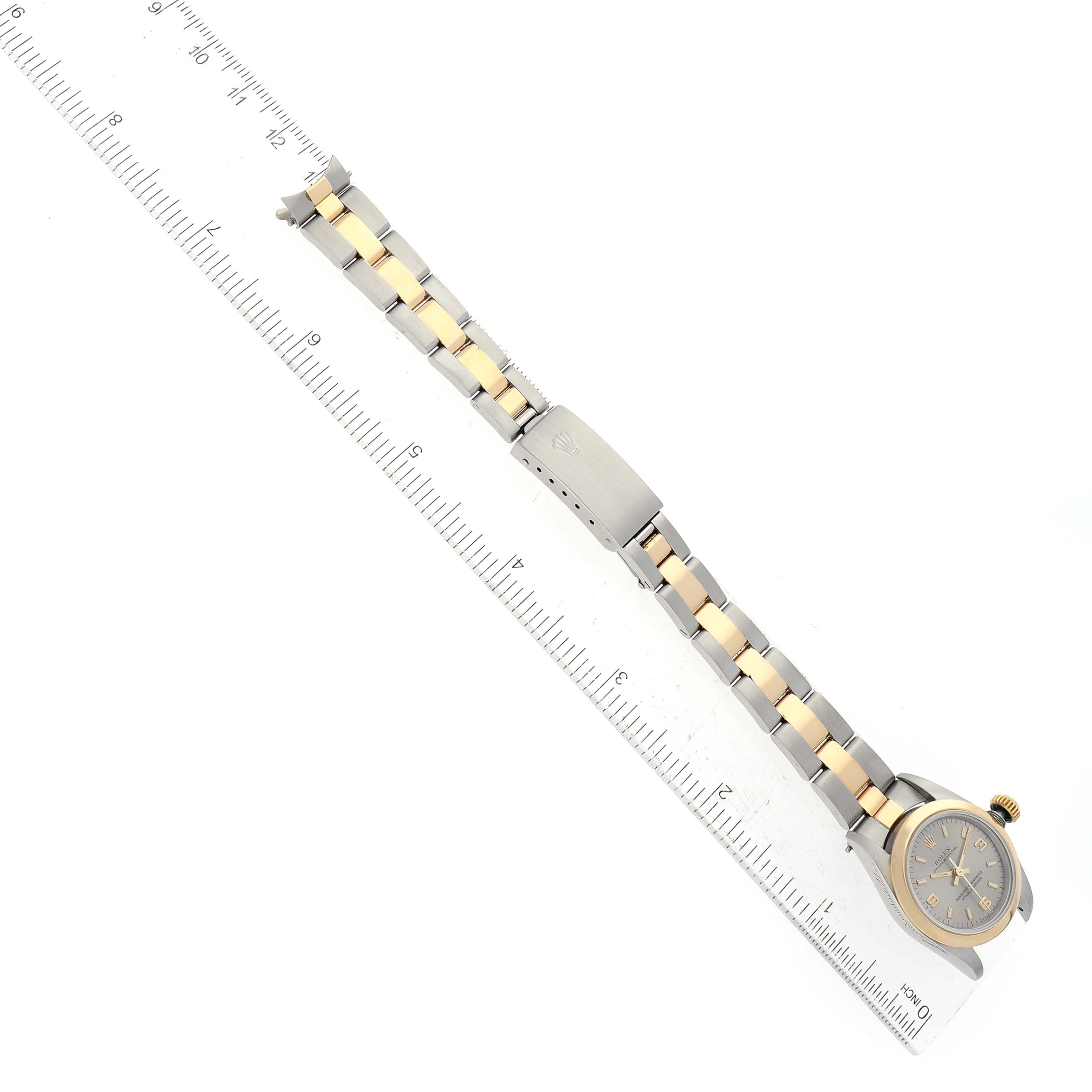 This image shows a Rolex Oyster Perpetual 67183 Women's Steel and Gold (two tone) Grey Dial 67183 Women's Steel and Gold (two tone) Grey Dial watch positioned flat, with its full bracelet and clasps visible alongside a ruler for scale.