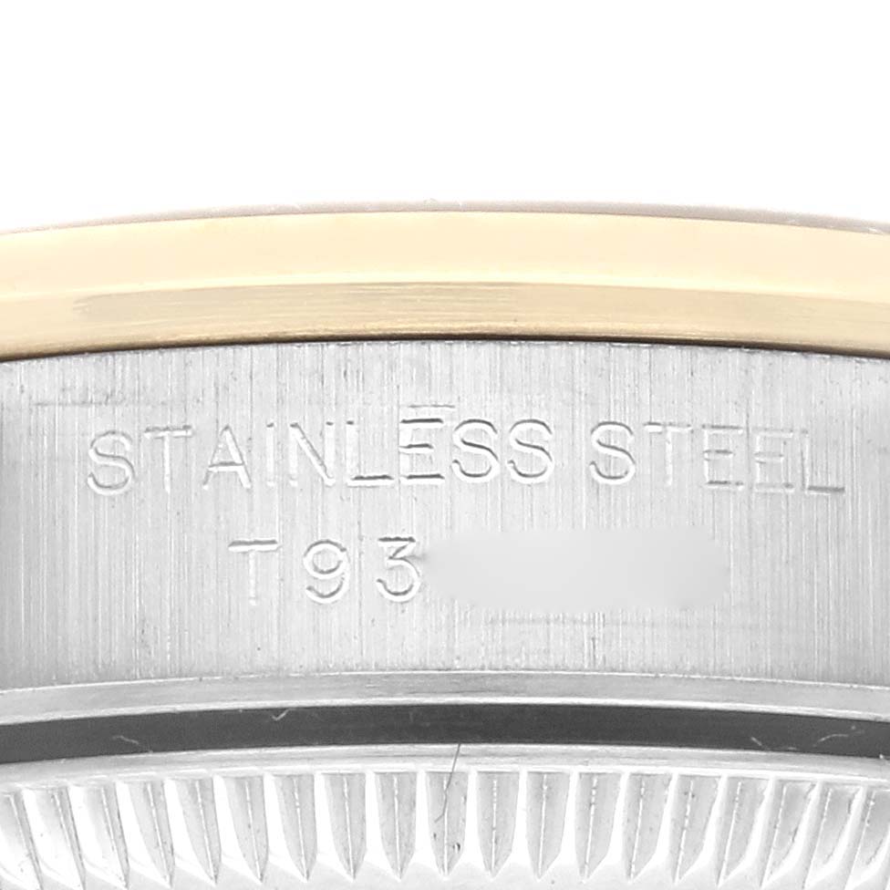 This close-up shot of a Rolex Oyster Perpetual 67183 Women's Steel and Gold (two tone) Grey Dial 67183 Women's Steel and Gold (two tone) Grey Dial watch shows a partial view of the stainless steel case with engraved markings.