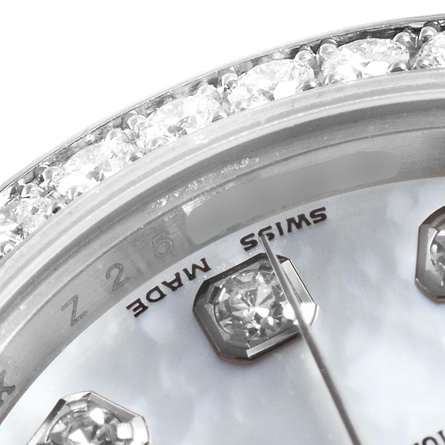 The close-up image of the Rolex President 179159 Women's White Gold Mother of Pearl Dial 179159 Women's White Gold Mother of Pearl Dial watch showcases the diamond-studded bezel, part of the dial, and a few diamond hour markers.