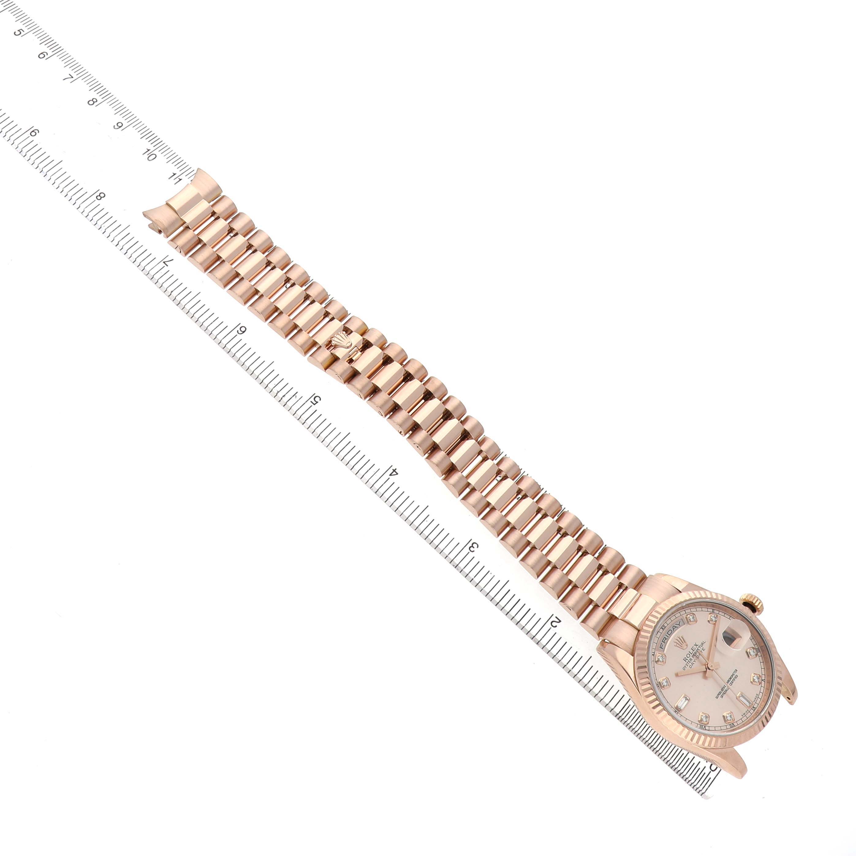 The Rolex President 118235 Men's Rose Gold Pink Dial model is shown at an angle with a full view of the watch face and bracelet, alongside a ruler.