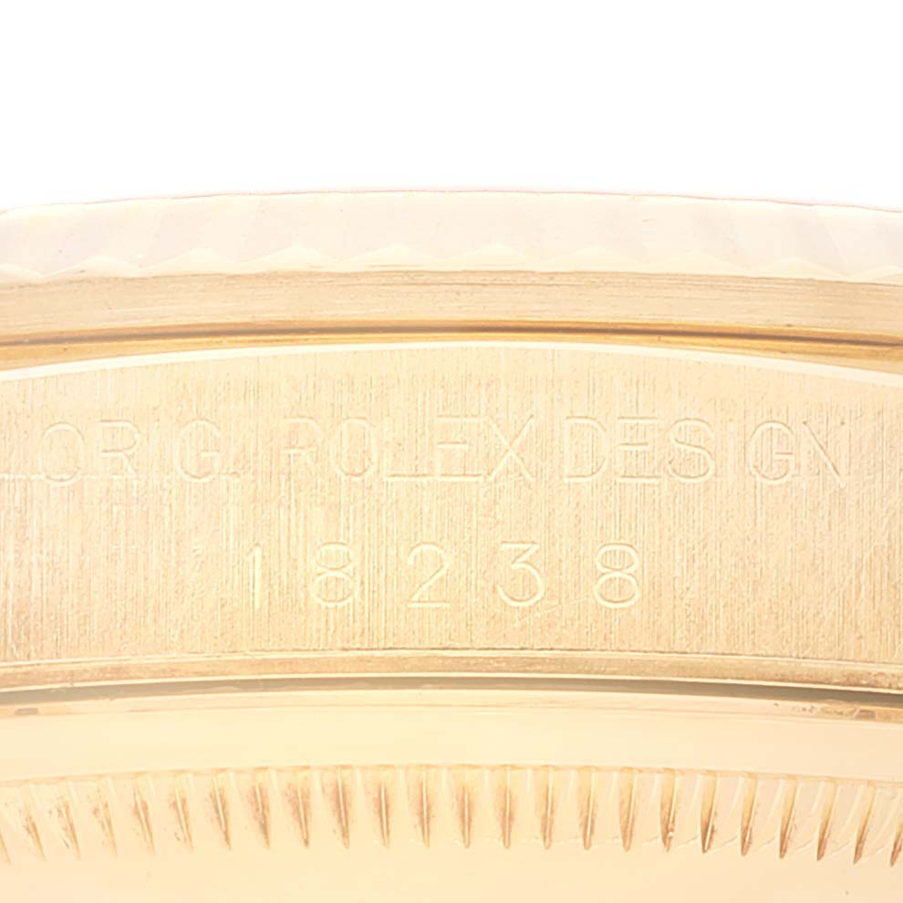 The image shows a close-up of the side of the bezel and case of a Rolex President 18238 Men
s Yellow Gold Black Dial 18238 Men
s Yellow Gold Black Dial model watch with the engravings in view.