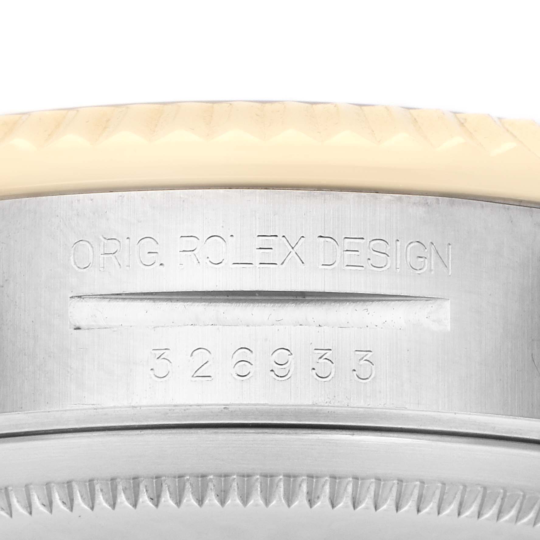 The image shows a close-up of the side of a Rolex Sky-Dweller 326933 Men
s Steel and Gold (two tone) Black Dial, focusing on the bezel and engraved design details.