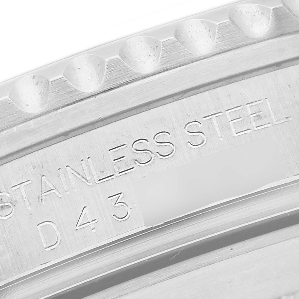 A close-up of the inscribed stainless steel bezel edge and case back of a Rolex Submariner 16610 Men's Stainless Steel Black Dial 16610 Men's Stainless Steel Black Dial watch.