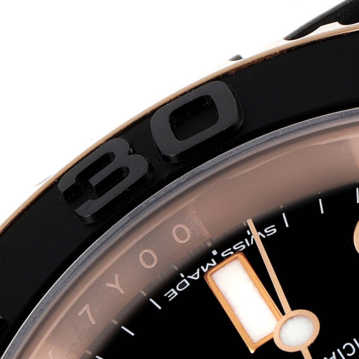 This close-up image shows part of the bezel, the number 30, and the edge of the dial on a Rolex Yacht-Master 116655 Men's Rose Gold Black Dial 116655 Men's Rose Gold Black Dial watch.