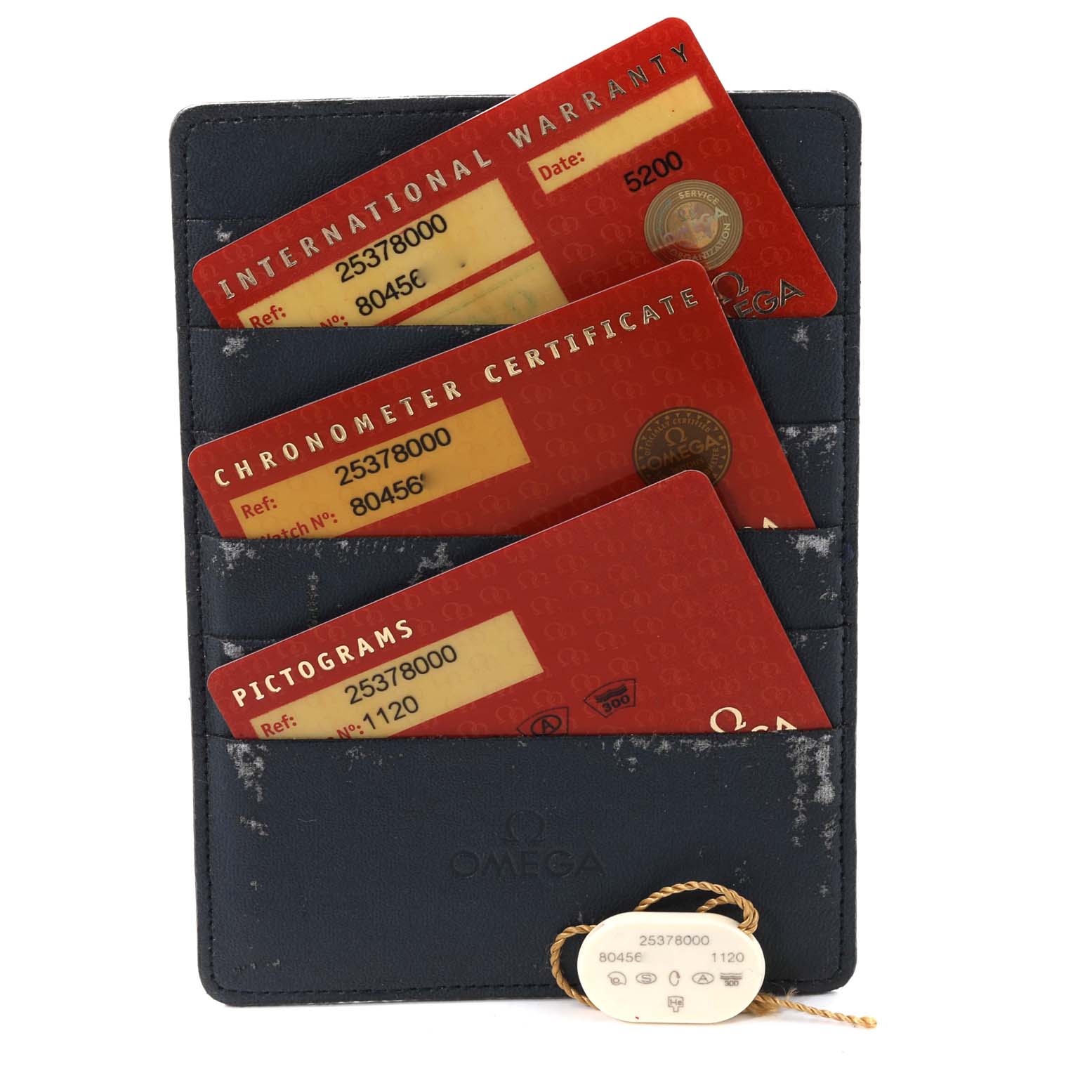 The image shows a card holder containing International Warranty, Chronometer Certificate, and Pictograms cards, along with a tag for an Omega Seamaster 2537.80.00 Men's Stainless Steel Blue Dial 2537.80.00 Men's Stainless Steel Blue Dial watch.