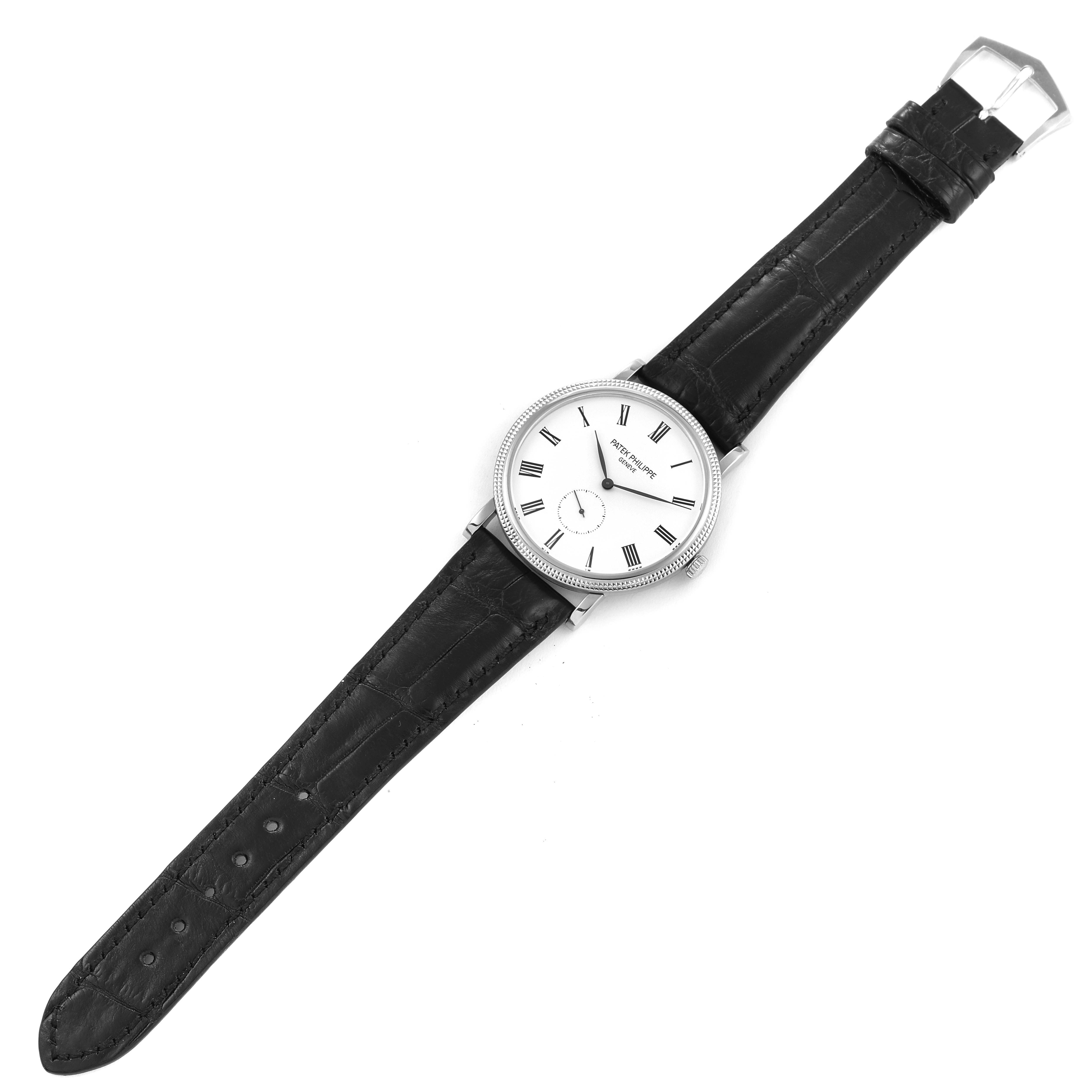 The image shows a top view of a Patek Philippe Calatrava 5119 Men's White Gold White Dial 5119 Men's White Gold White Dial watch with its face, strap, buckle, and crown visible.