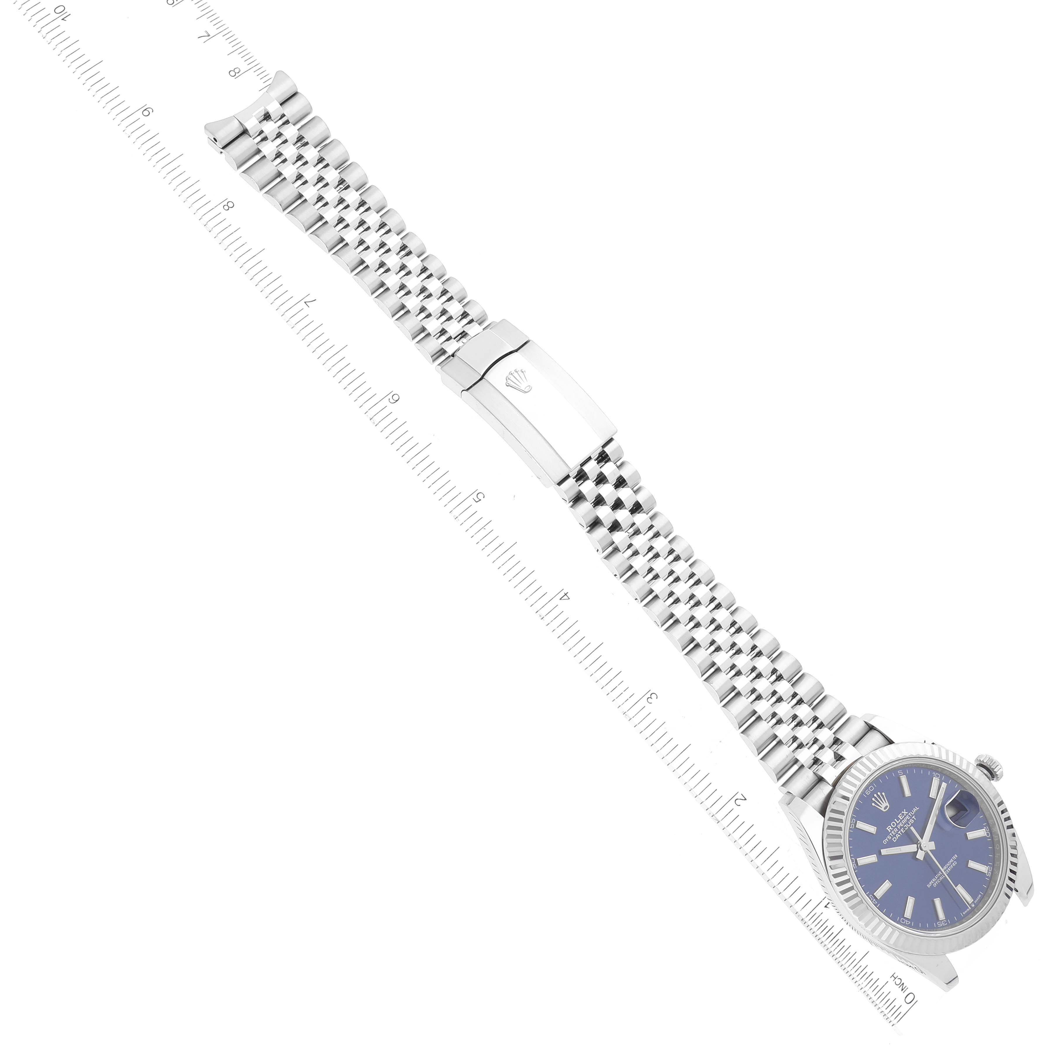 The image shows a top-view angle of the Rolex Datejust 41 126334 Men
s Stainless Steel Blue Dial 126334 Men
s Stainless Steel Blue Dial watch, highlighting its blue dial, bracelet, and clasp alongside a ruler.
