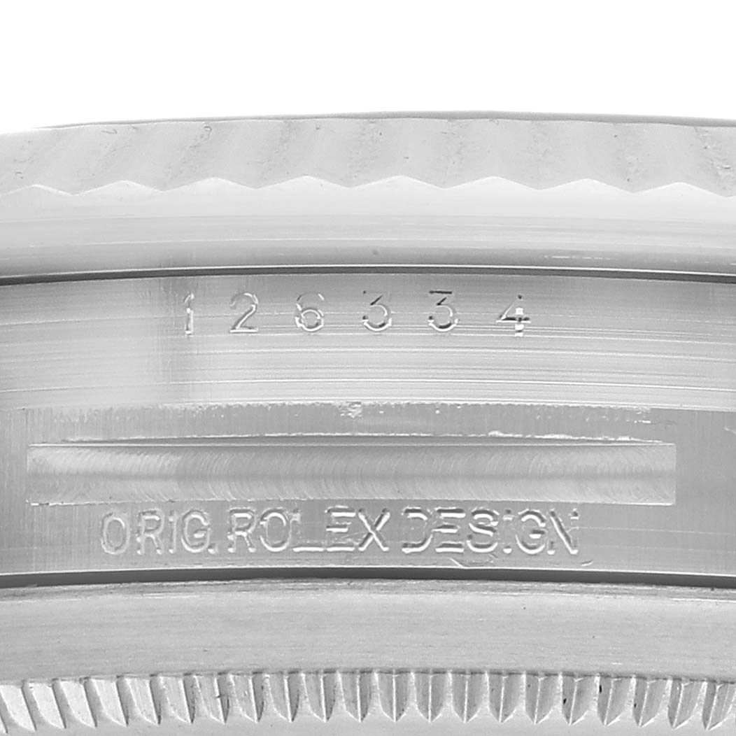 The image shows a close-up of the inner bezel with markings and the fluted bezel edge of the Rolex Datejust 41 126334 Men's Stainless Steel Blue Dial.