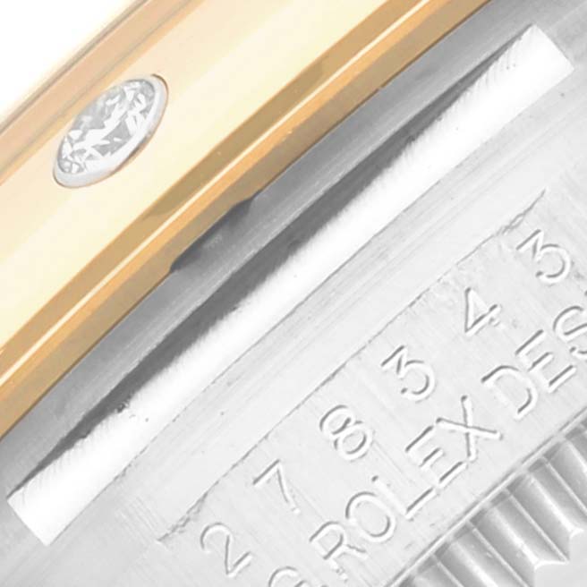 This close-up image of a Rolex Mid-Size 278343 Women's Steel and Gold (two tone) Grey Dial 278343 Women's Steel and Gold (two tone) Grey Dial watch shows part of the bezel with a diamond and engraved text on the case.
