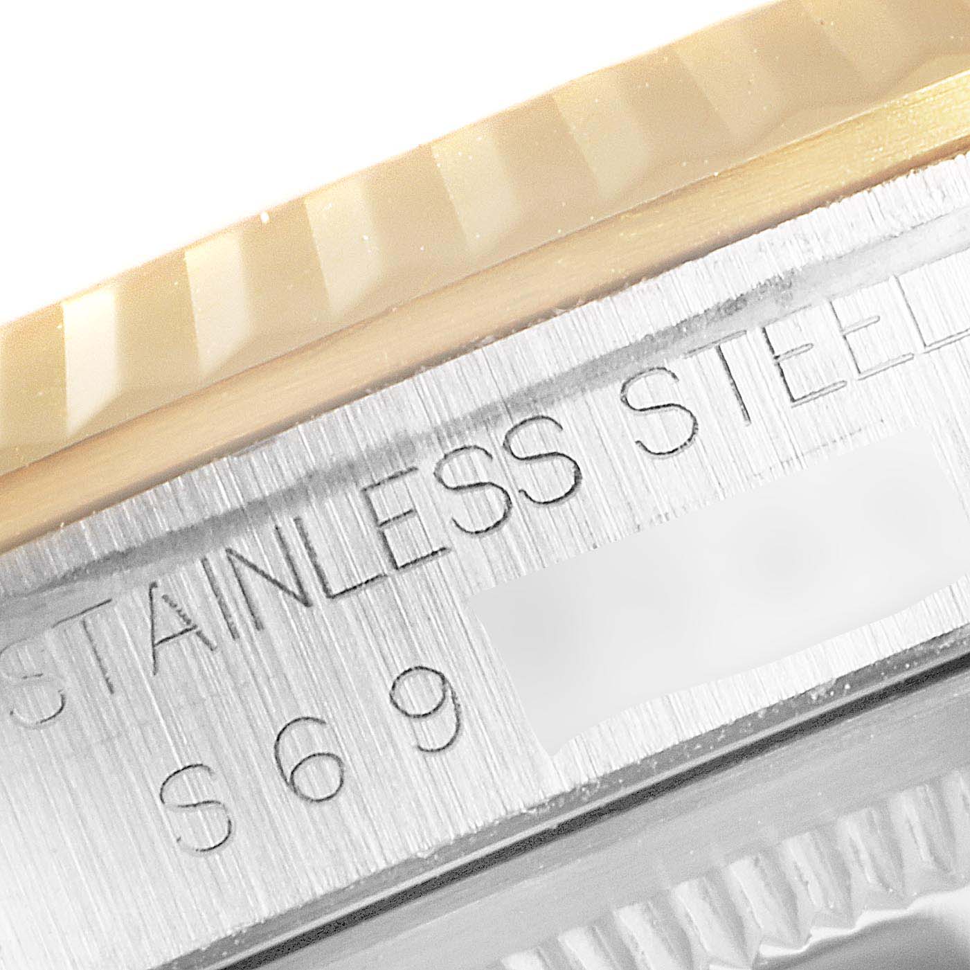 This close-up image of a Rolex Datejust 16233 Men
s Steel and Gold (two tone) Champagne Dial 16233 Men
s Steel and Gold (two tone) Champagne Dial watch displays the fluted bezel and part of the case with "STAINLESS STEEL" engraving.