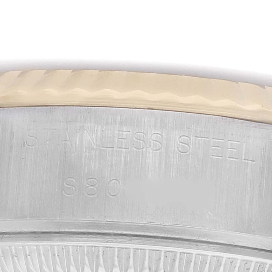 The image shows a close-up of the side of a Rolex Datejust 69173 Women's Steel and Gold (two tone) Champagne Dial, highlighting the bezel and engraved "STAINLESS STEEL" text.