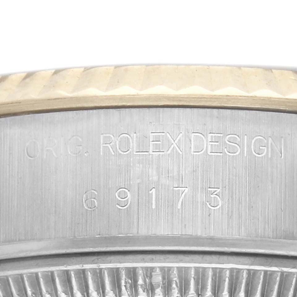 The image shows a close-up of the side of a Rolex Datejust 69173 Women's Steel and Gold (two tone) Champagne Dial, highlighting the engraved design details and model number.