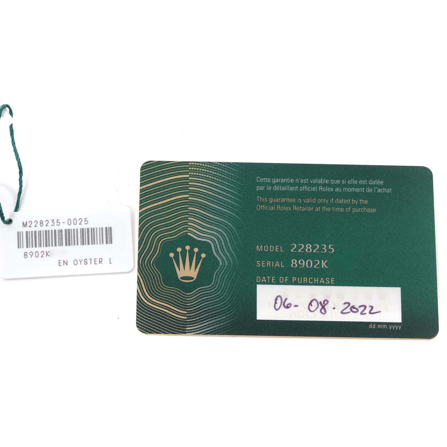 The image shows a guarantee card and a tag for a Rolex President 228235 Men's Rose Gold Green Dial 228235 Men's Rose Gold Green Dial model watch, with details such as model and serial numbers.