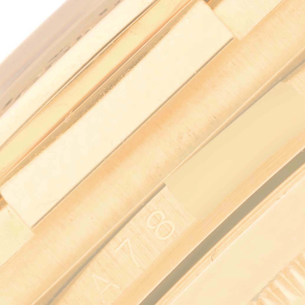 This close-up image shows a part of the gold bracelet links and clasp of a Rolex Daytona 16518 Men's Yellow Gold Black Dial 16518 Men's Yellow Gold Black Dial watch.