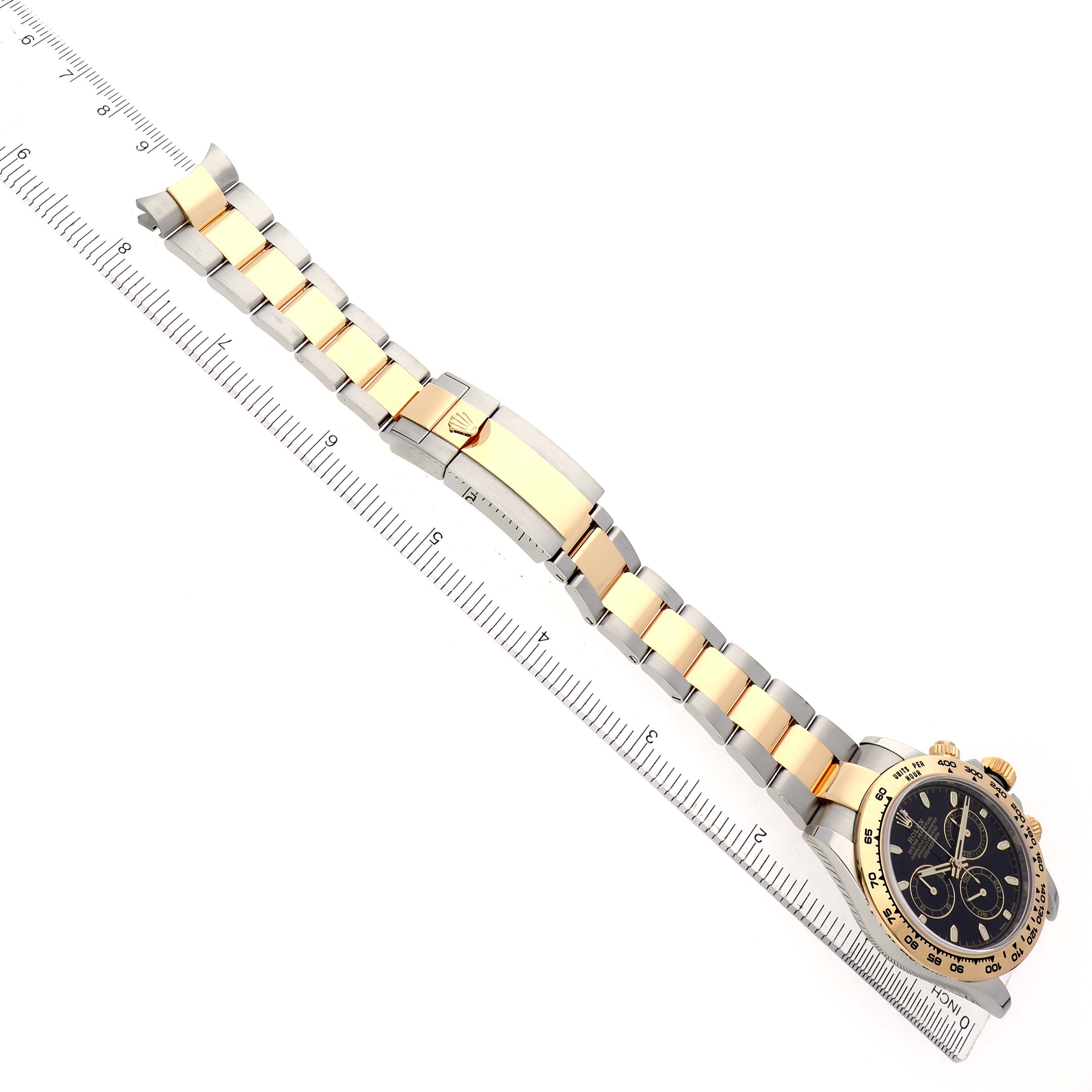 The Rolex Daytona 116503 Men
s Steel and Gold (two tone) Black Dial watch is shown from an overhead angle, displaying the full bracelet and face with a ruler for scale.