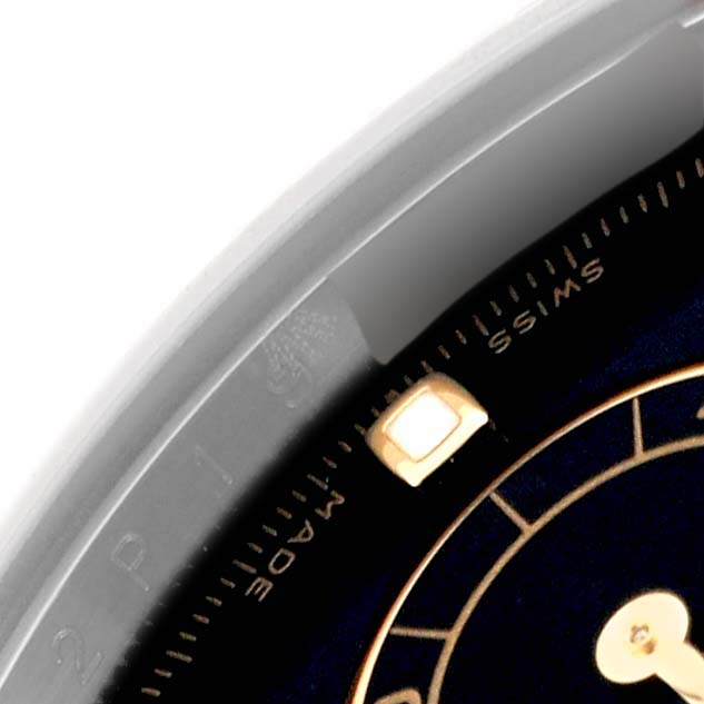 The image shows a close-up of the dial and part of the bezel of the Rolex Daytona 116523 Men's Steel and Gold (two tone) Black Dial 116523 Men's Steel and Gold (two tone) Black Dial watch, featuring the "SWISS MADE" inscription.