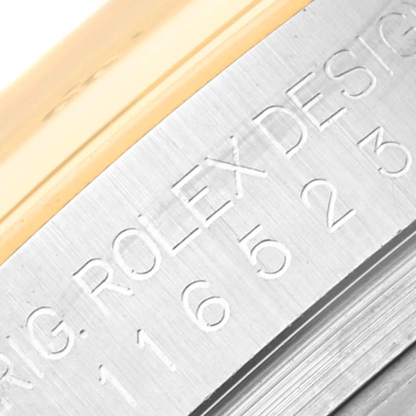 This close-up image shows the engravings on the side of the Rolex Daytona 116523 Men's Steel and Gold (two tone) Black Dial 116523 Men's Steel and Gold (two tone) Black Dial watch case.