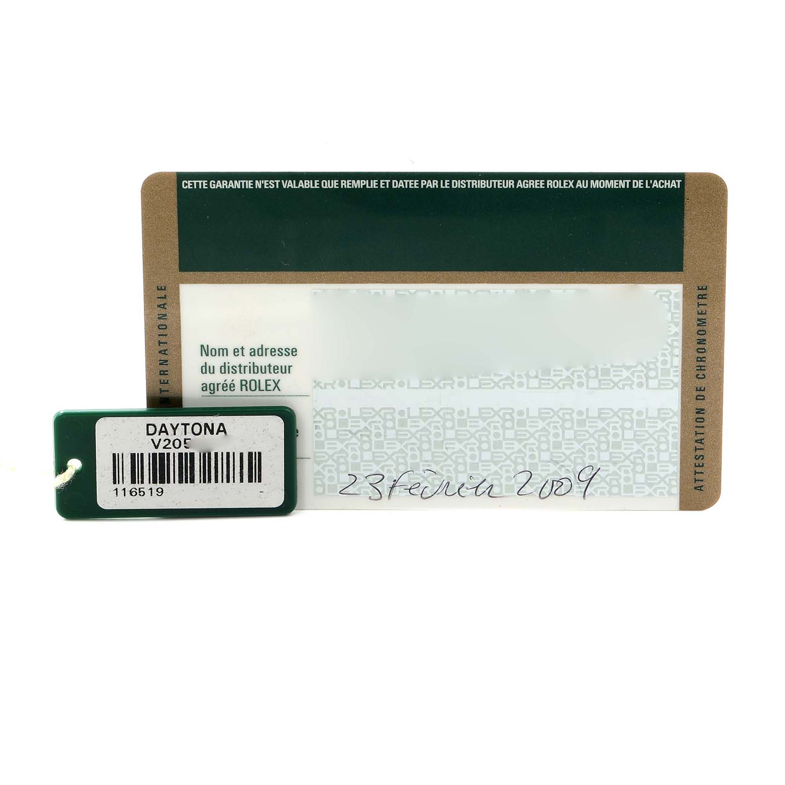 The image shows a Rolex Daytona 116519 Men
s White Gold Silver Dial warranty card and a green tag with model and serial numbers.