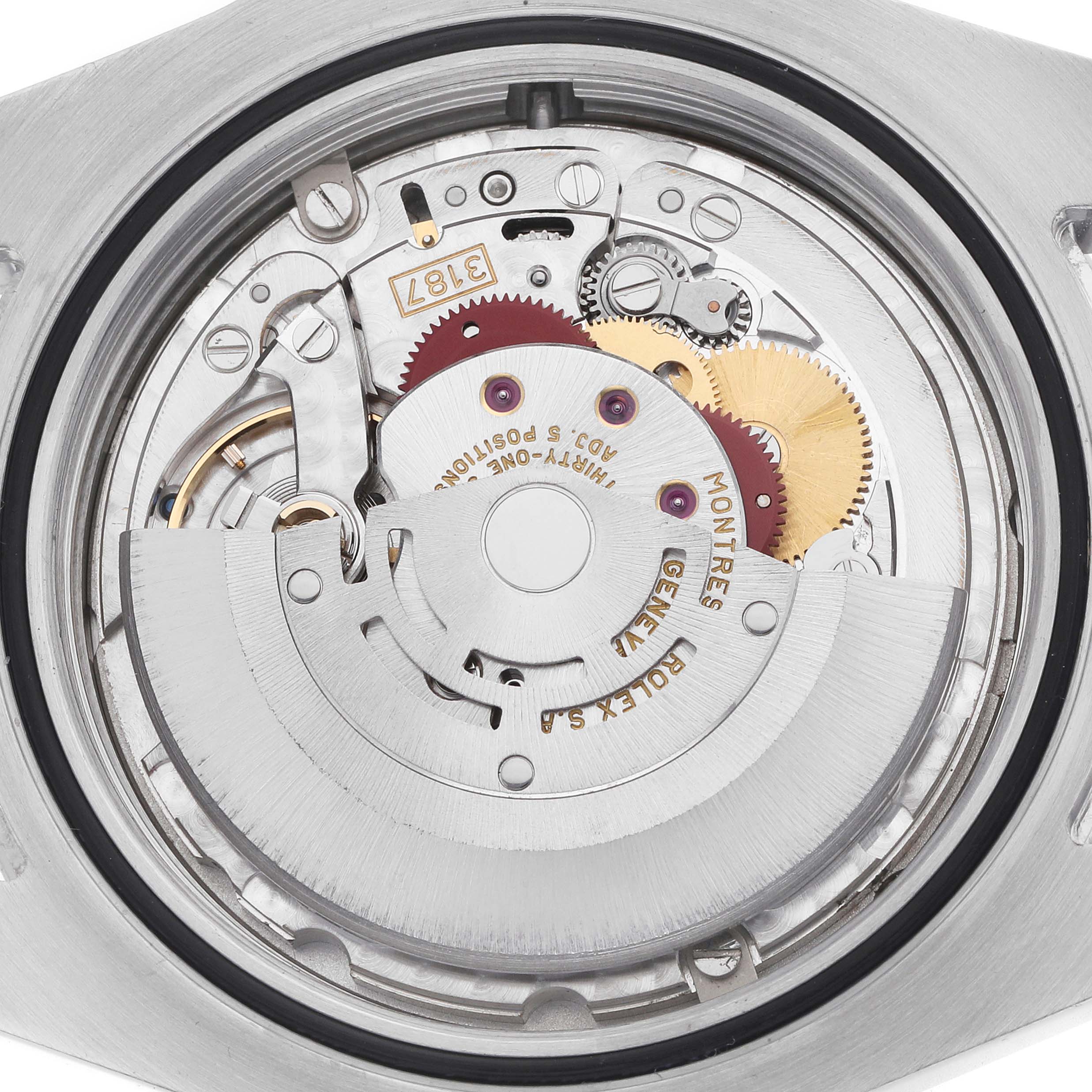 The image shows a detailed view of the movement inside a Rolex Explorer 216570 Men
s Stainless Steel Black Dial watch, highlighting gears and the rotor mechanism.