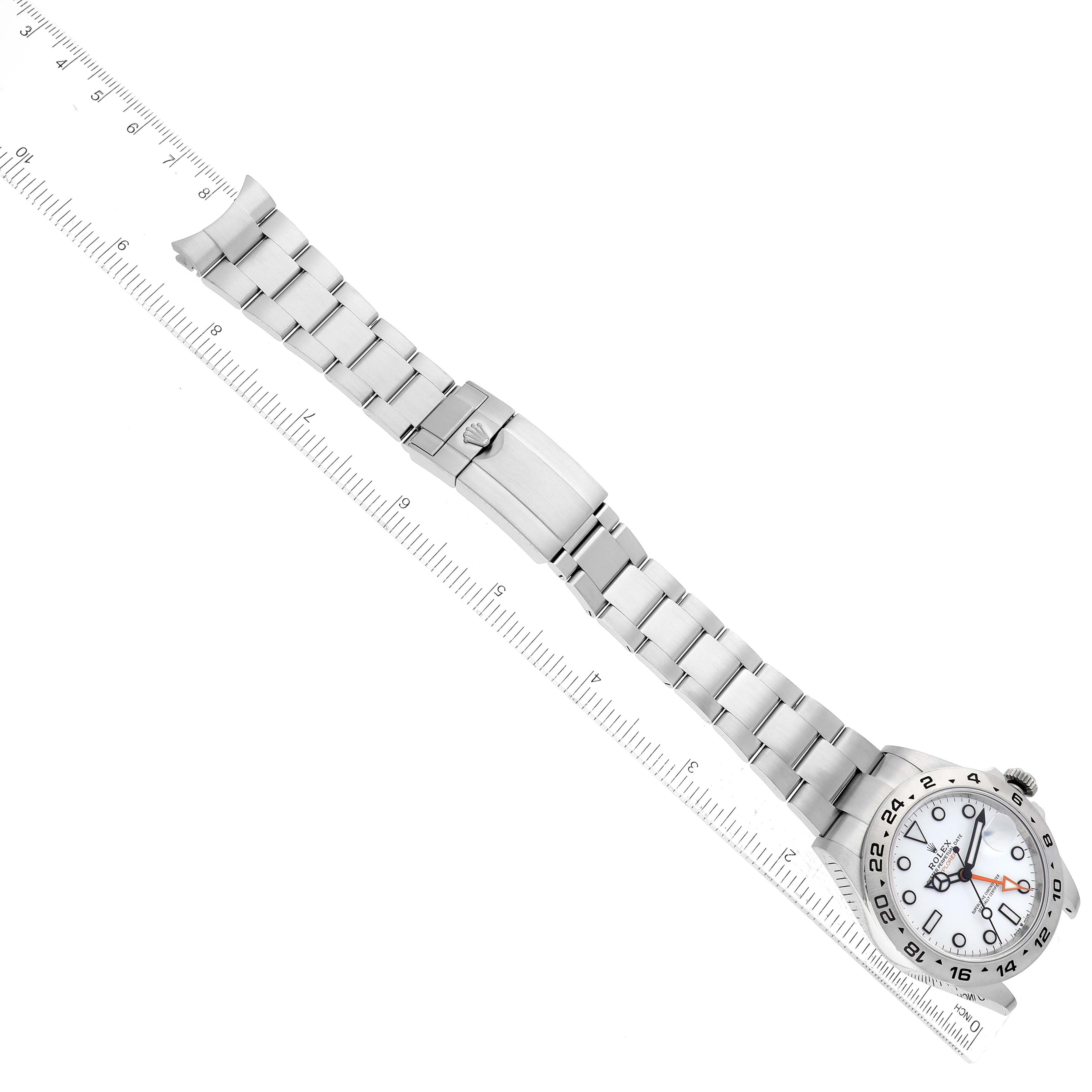 This image shows a top-down view of a Rolex Explorer 226570 Men's Stainless Steel White Dial 226570 Men's Stainless Steel White Dial model watch, displaying the entire watch and band alongside a measuring scale.