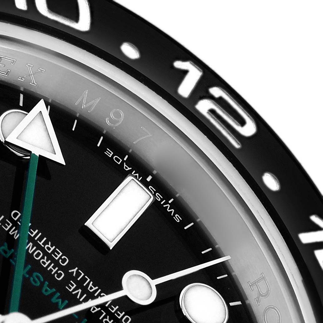 The image shows a close-up of the Rolex GMT-Master 116710 Men's Stainless Steel Black Dial's bezel, partial face, and hands from an overhead angle.