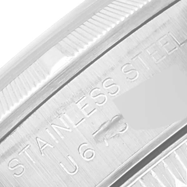 The image shows a close-up of the edge and inner engraving of the stainless steel case for a Rolex Oyster Perpetual 67230 Women's Stainless Steel Pink Dial 67230 Women's Stainless Steel Pink Dial watch.