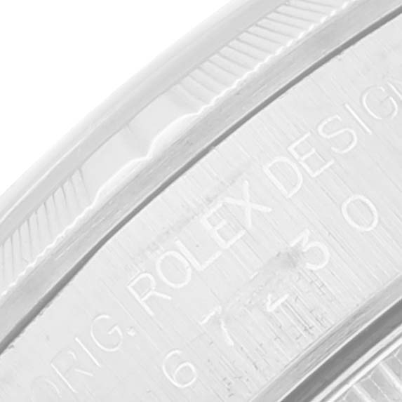 Close-up of the side of the Rolex Oyster Perpetual 67230 Women's Stainless Steel Pink Dial 67230 Women's Stainless Steel Pink Dial watch showing engraved text "ORIG. ROLEX DESIGN."