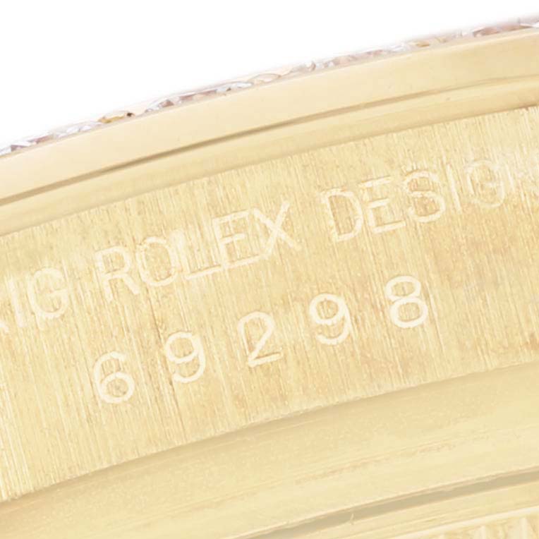 This close-up image shows the engraved serial number and part of the gold casing of a Rolex Pearlmaster 69298 Women's Yellow Gold Champagne Dial 69298 Women's Yellow Gold Champagne Dial watch.