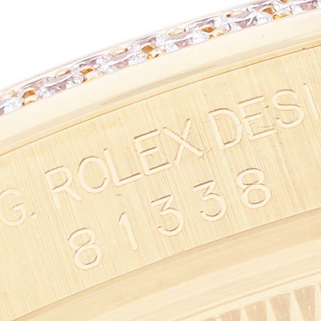 The image shows a close-up of the side of a Rolex Pearlmaster 81338 Women
s Yellow Gold Mother of Pearl Dial watch, featuring its engraved model details and part of the diamond-encrusted bezel.
