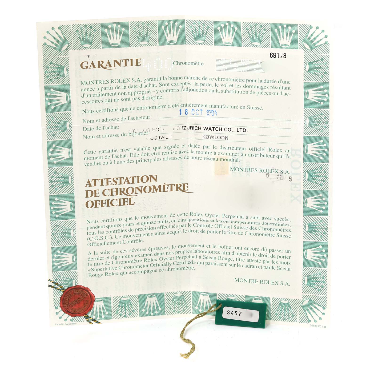 The image shows a Rolex warranty document and a green tag for a President model from a front, top-down angle.