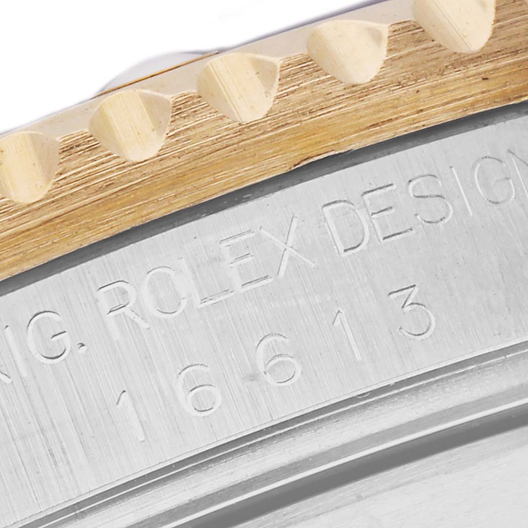 This image shows a close-up of the bezel and engraved model number on a Rolex Submariner 16613 Men's Steel and Gold (two tone) Blue Dial 16613 Men's Steel and Gold (two tone) Blue Dial watch.