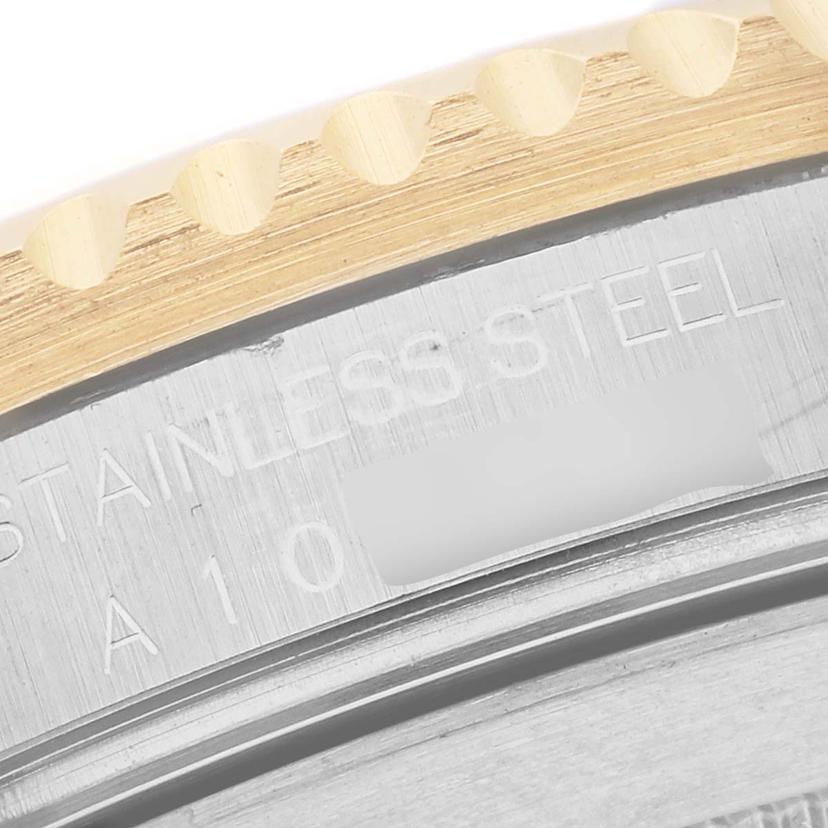 The image shows a close-up of the stainless steel and gold bezel of a Rolex Submariner 16613 Men's Steel and Gold (two tone) Blue Dial 16613 Men's Steel and Gold (two tone) Blue Dial watch, highlighting the text engraving.
