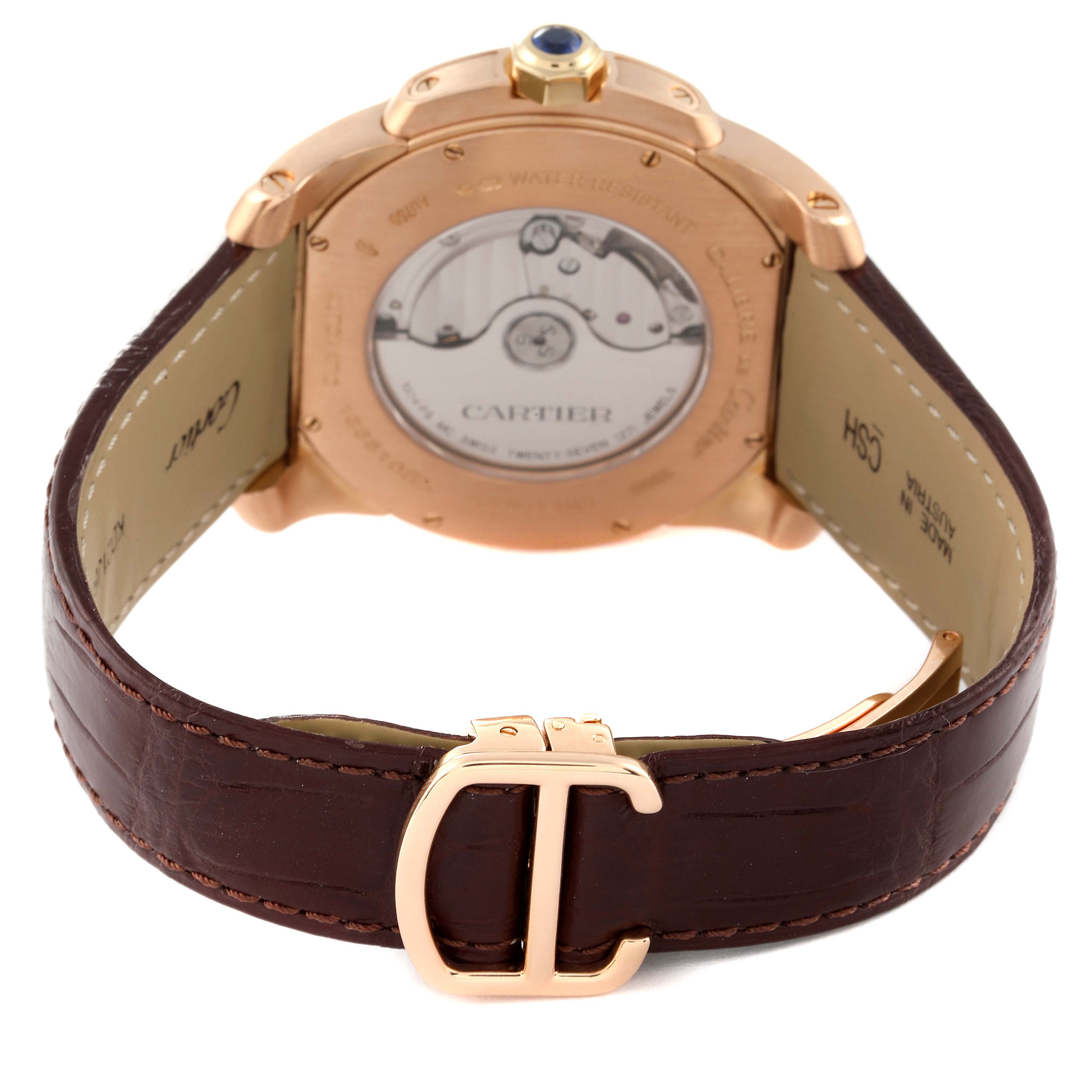 The image shows the back view of the Calibre de Cartier watch by Cartier, highlighting the case back and leather strap with a "C" buckle.