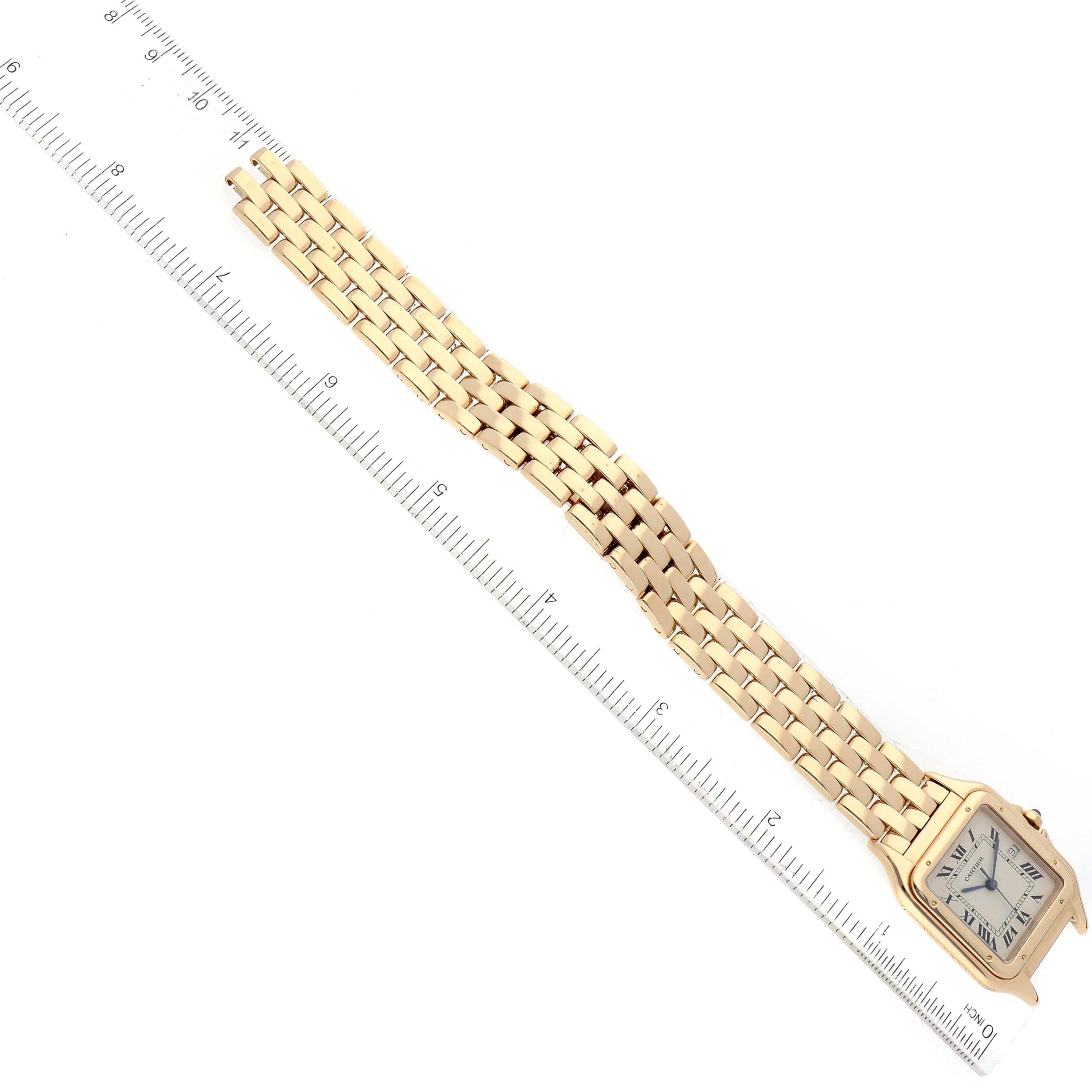 The Cartier Panthere W2501489 Women's Yellow Gold Silver Dial W2501489 Women's Yellow Gold Silver Dial watch is shown from an overhead angle, highlighting the face and full gold bracelet along with a ruler for scale.