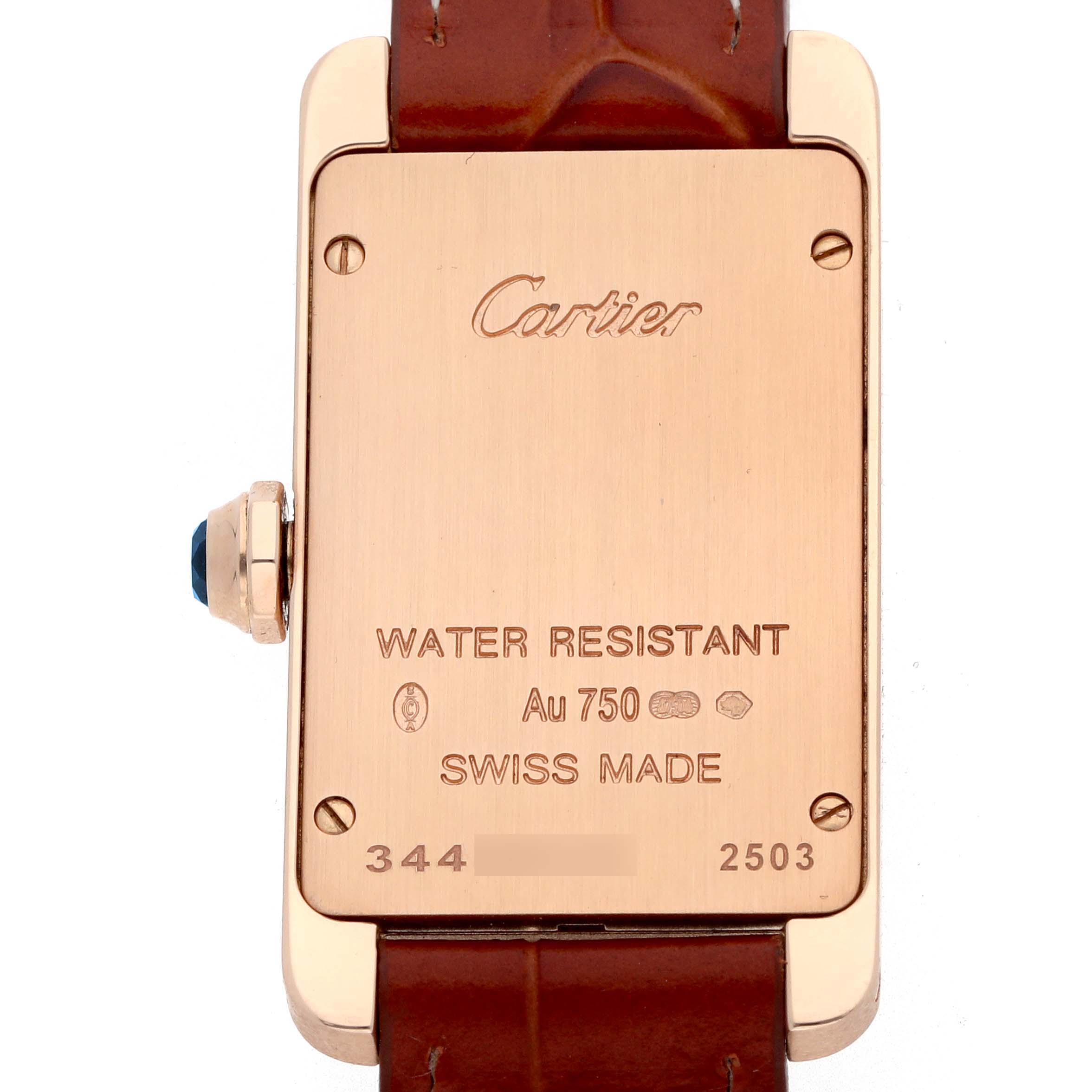 The image shows the back case of the Cartier Tank Americaine W2607456 Women's Rose Gold Silver Dial watch with engravings visible, including water resistance and material details.