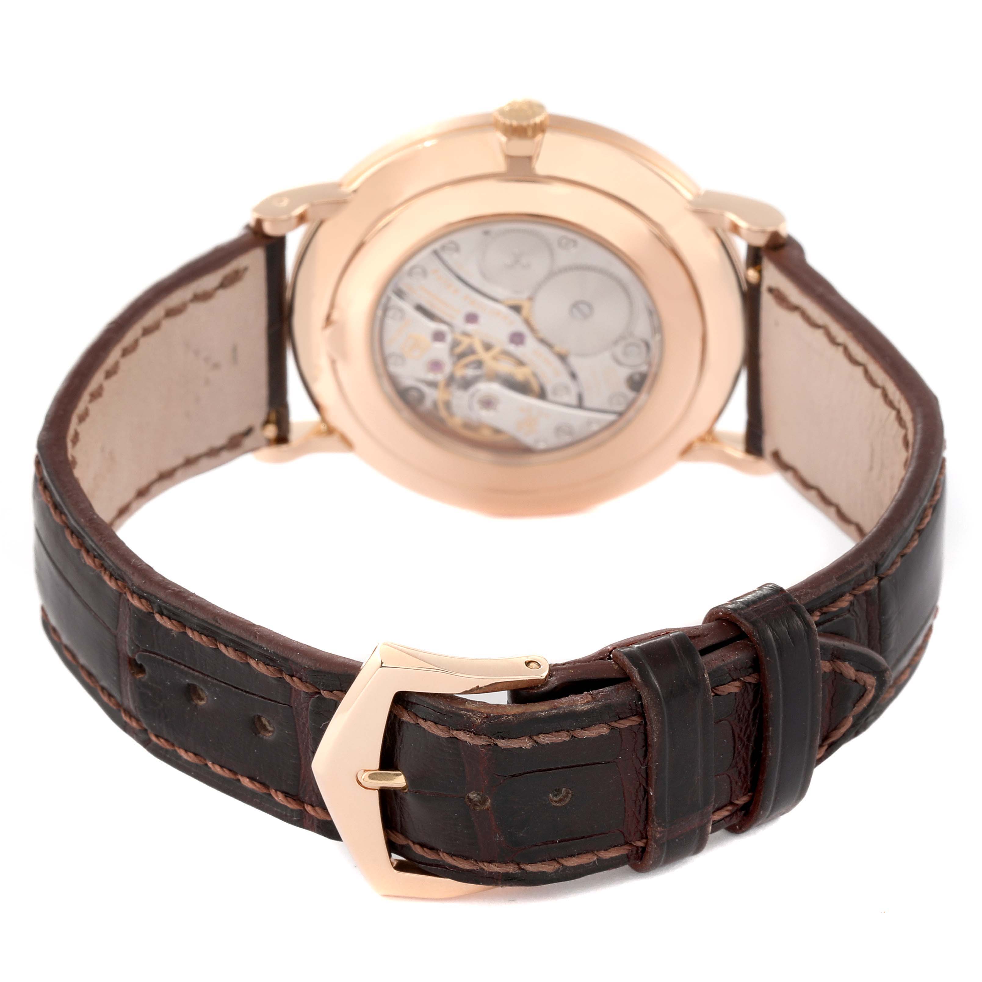 This image shows the back view of a Patek Philippe Calatrava 5119R Men's Rose Gold White Dial 5119R Men's Rose Gold White Dial watch, highlighting its leather strap and the watch's intricate case back.