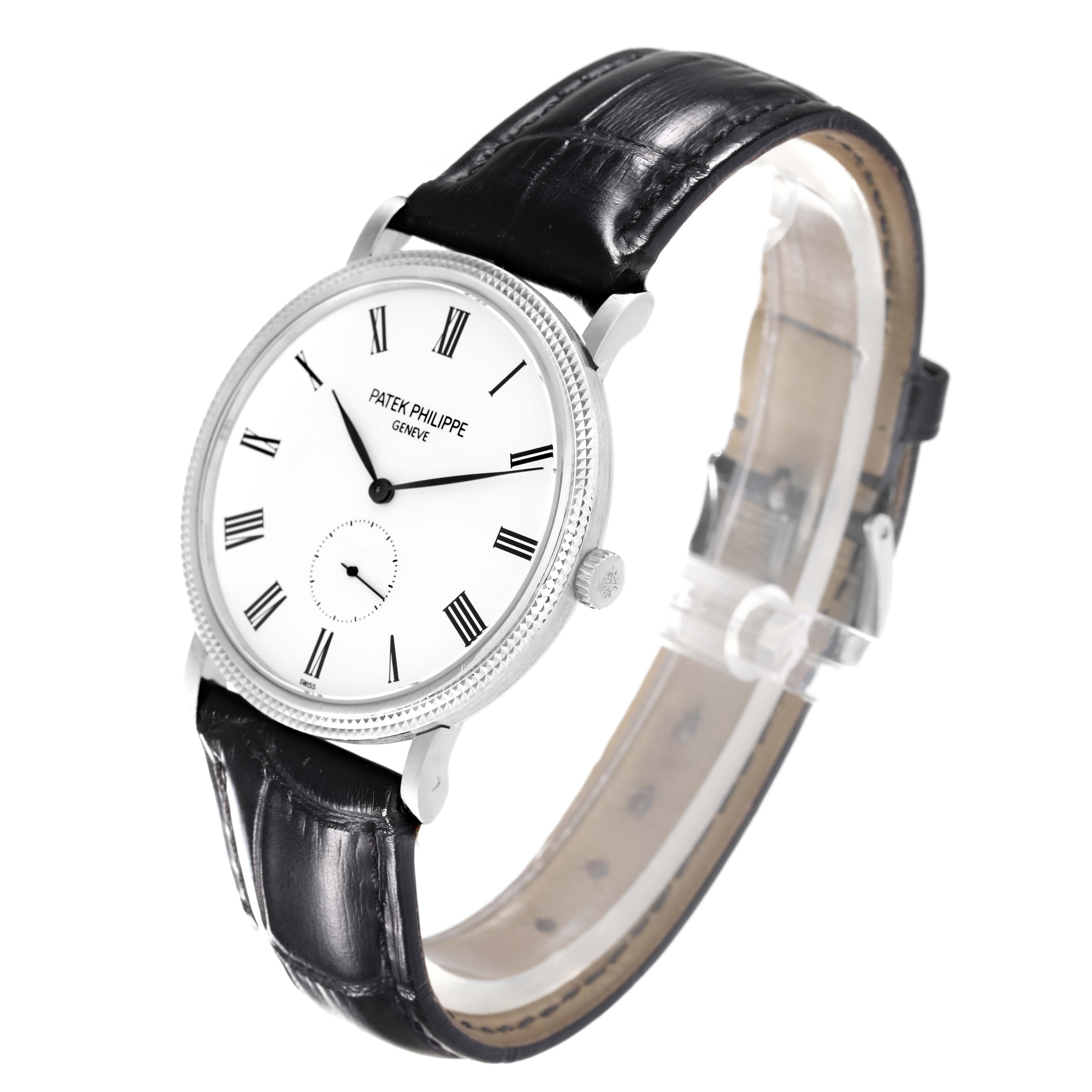 The image showcases a Patek Philippe Calatrava 5119G-001 Men's White Gold White Dial 5119G-001 Men's White Gold White Dial watch at an oblique angle, highlighting its white dial, Roman numerals, and black leather strap.