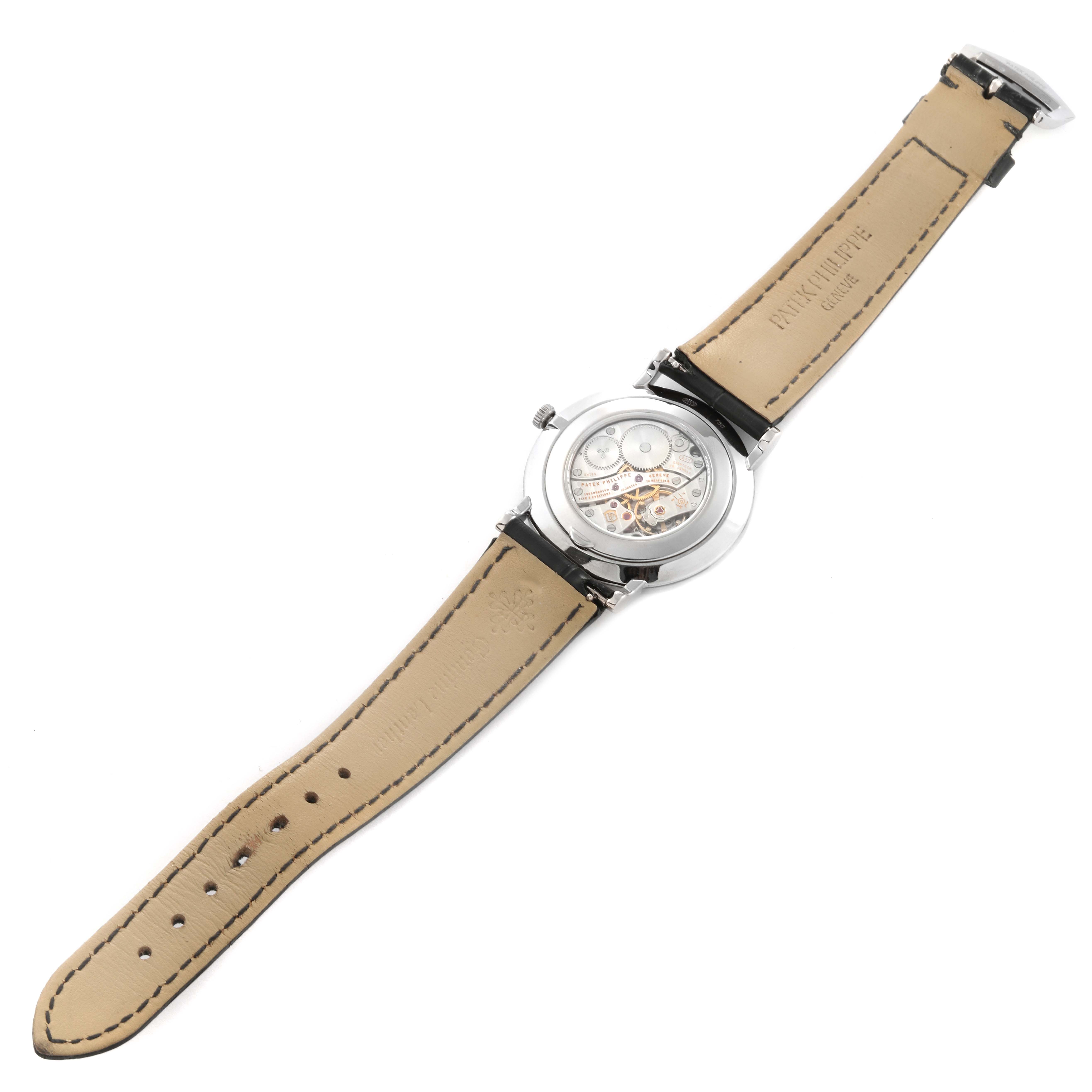 The image shows the back view of a Patek Philippe Calatrava 5119G-001 Men's White Gold White Dial 5119G-001 Men's White Gold White Dial watch, highlighting its exposed movement and leather strap.