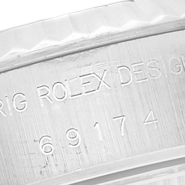 The image shows an angled close-up of the Rolex Datejust 69174 Women's Stainless Steel White Dial 69174 Women's Stainless Steel White Dial model, specifically focusing on the serial number and engraved branding.